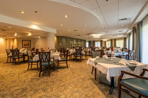 Dining room with set tables, upholstered chairs and large windows