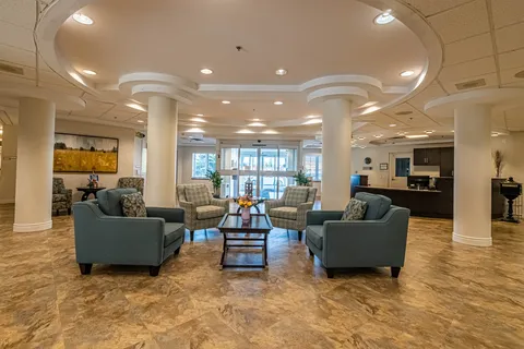 Lobby with sofas, armchairs, round columns and glass entrance doors