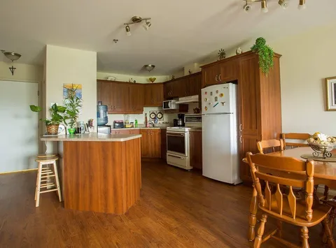 Suite kitchenette with wooden cabinets and a refrigerator.