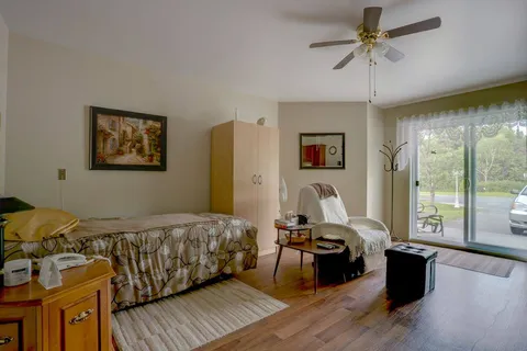 Suite bedroom with a bed, dresser and window.