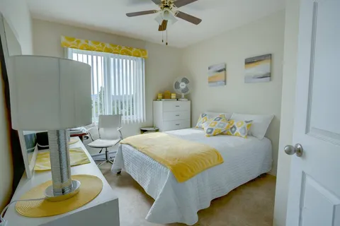 Bedroom with a bed beside large windows.