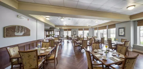 Dining room with set wooden tables, chairs and windows