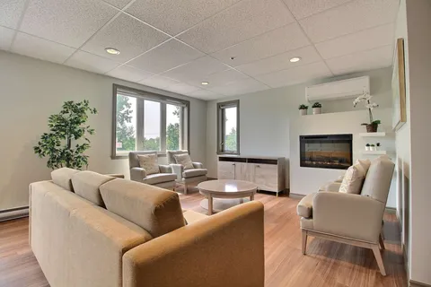 Common sitting room with sofas and a fireplace.