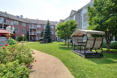 Courtyard path with flowers and a covered garden swing.