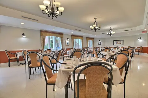 Dining room with set tables and ceiling lights.
