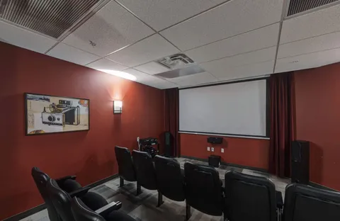 Cinema room with a blank projection screen and black seats