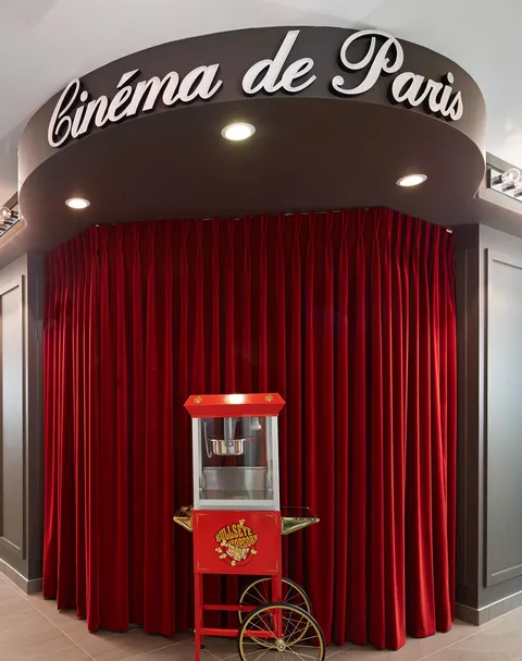 Cinema entrance with red curtains and a popcorn cart
