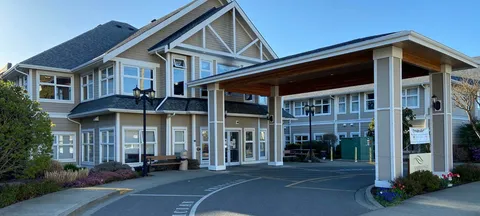 Two-storey building with a large covered entrance and paved driveway