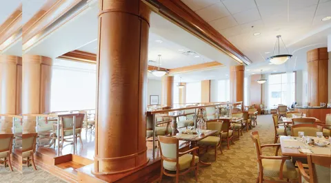 Dining room with set tables and chairs beside large windows