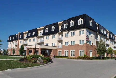 Multistorey building with a covered entrance, driveway and landscaped beds