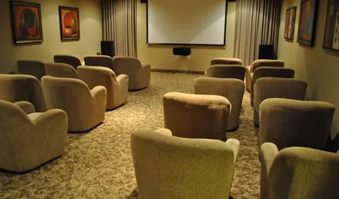 Screening room with armchairs facing a projection screen