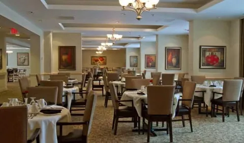 Dining room with tables, upholstered chairs and chandeliers
