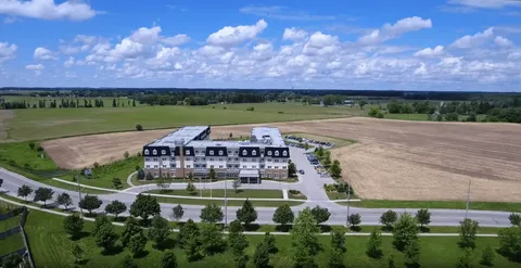 Aerial view of a multistorey building surrounded by lawns and fields
