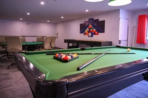 Games room with a billiards table and cushioned chairs
