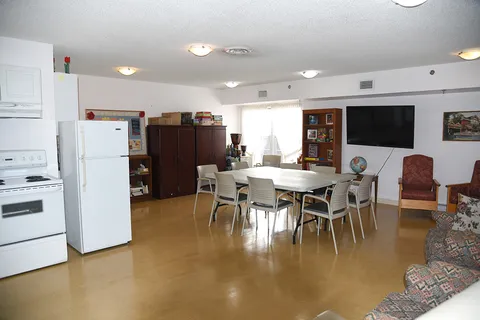 Common room with kitchenette, table and chairs.