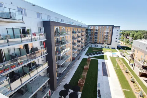 Residence towers above landscaped gardens and paths.
