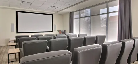 Theatre with rows of seats facing a blank screen.