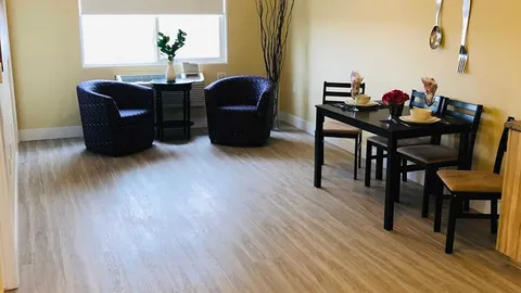 Suite sitting and dining area with armchairs and a table.