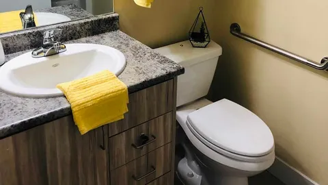 Bathroom with a sink, toilet and grab rail.