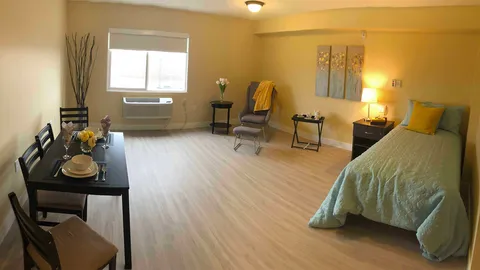 Studio suite with a bed, dining table and sitting area.