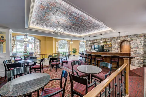 Bistro seating with round tables, chairs and windows.