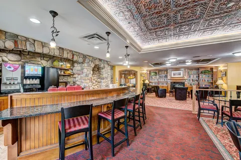 Bistro counter with stools, tables and stone walls.