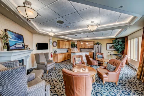 Lounge with upholstered seating and a fireplace.