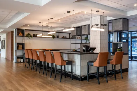 Counter with orange bar stools, shelves and hanging lights