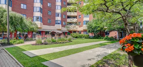 Outdoor shuffleboard court beside lawns, trees and flower beds