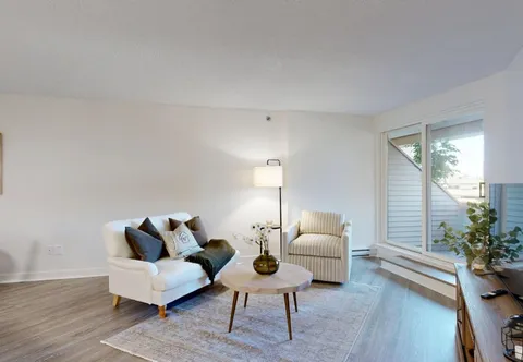 Sitting area with a white sofa, striped armchair and coffee table