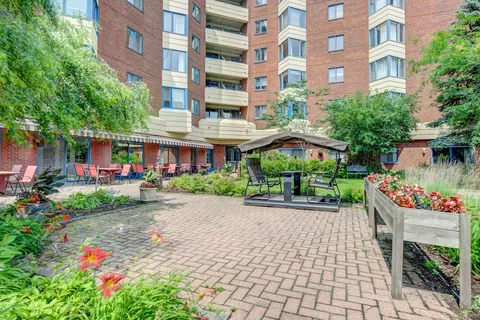 Brick residential building around a planted courtyard with paved paths