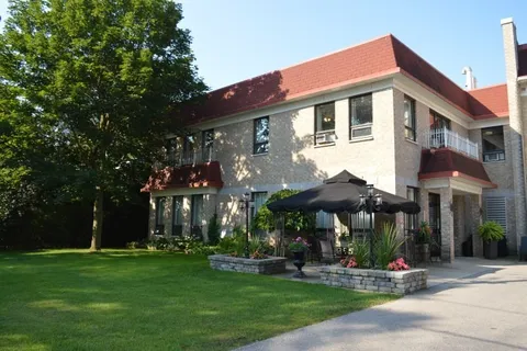 Two-storey residence with a red roof and a lawn