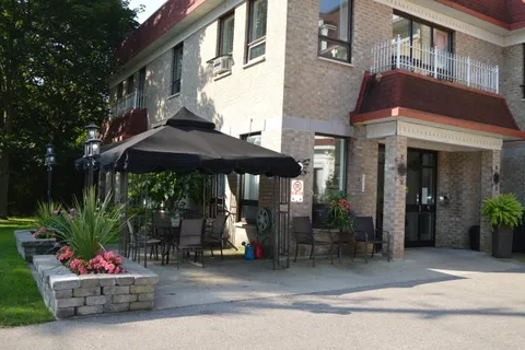 Residence entrance beside flower beds and a patio umbrella