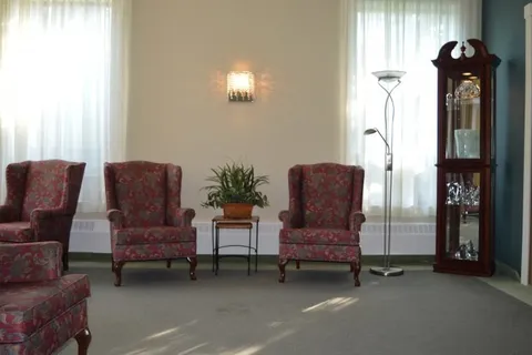 Room with red patterned armchairs and a grandfather clock
