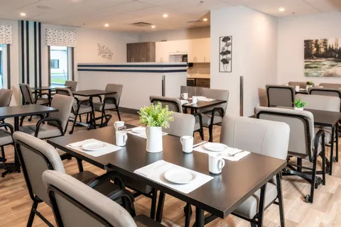 Dining room with set tables, cushioned chairs and plants