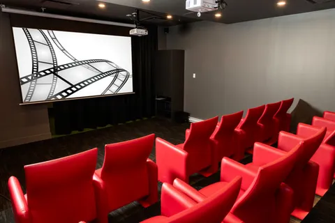 Theatre room with red seats and a screen showing a filmstrip design