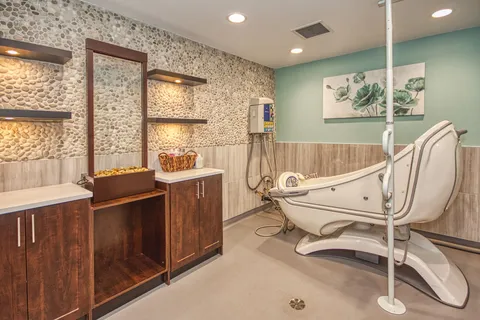 Spa room with a reclining chair and wooden storage cabinets