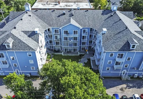 Aerial view of a blue residence surrounding a courtyard with trees