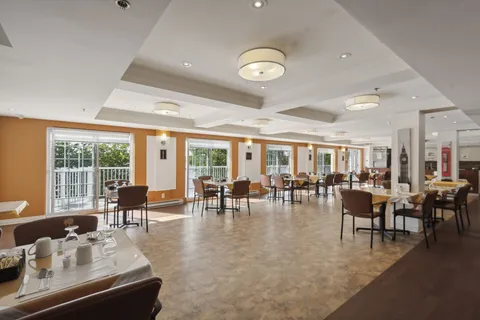 Dining room with set tables, upholstered chairs and large windows