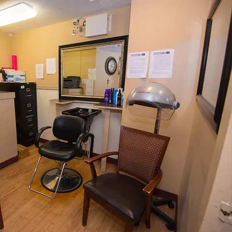 Salon with a styling chair, wall mirror and hooded hair dryer