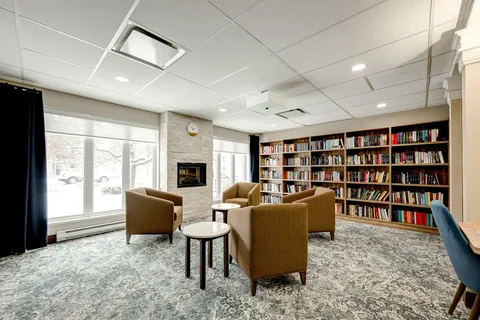 Library with armchairs, bookcases and a fireplace