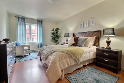 Bedroom with a double bed, dresser and armchair