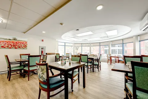Dining room with square tables, upholstered chairs and windows