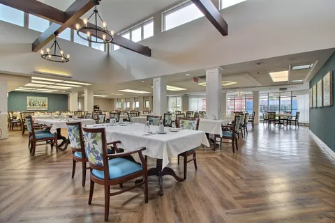 Dining room with tables, upholstered chairs and chandeliers